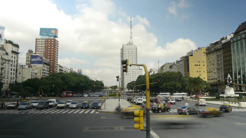 Vehicles & pedestrians passing by a big avenue. Wide Shot. Intersection Time-Lapse. Day Time. Hi angle. 9 de Julio, Buenos Aires, Argentina