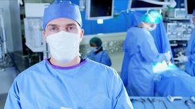 Portrait of Caucasian male surgeon observing Surgical healthcare medical training team in scrubs working in modern hospital operating theater facility performing Laparoscopic surgery on patient 