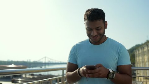 Excited Indian man typing on mobile phone