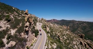 Cars driving down a curved Mt.Lemon road in Tucson AZ.