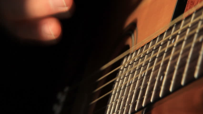 Acoustic Guitar Strumming 2. Close-up shot of a hand with a pick strumming an