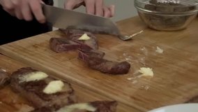 Hands cutting cooked beef steak to portions for serving