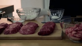 Chops of raw meat of different aging on a wooden cutting board