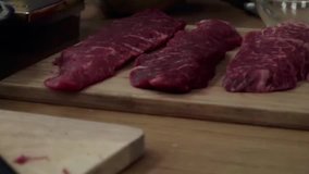 Raw marbled beef steaks of different aging on a wooden cutting board