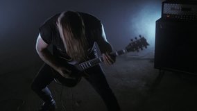 Brutal man metalhead plays the electric guitar. Music video punk, heavy metal or rock group.