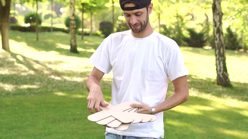 Portrait of a young man who is holding a large pieces for playing tic tac toe.