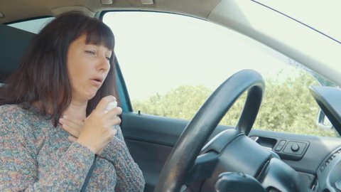 Young Sick Virus Cold Woman Coughing Sitting at Wheel of Car. Girl Suffers From Headache with Symptoms of Virus, Influenza, SARS. Healthcare and Medical Concept. Symptoms of Coronavirus.