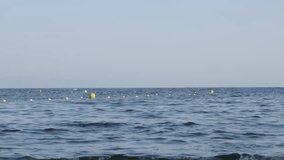 Row of swimming zone border signs 4K 2160p UltraHD footage - Blue sea and yellow buoys as swim area signs 3840X2160 UHD video