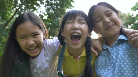 4K : Group of little happy Asian girls playing together in the park, Pan shot
