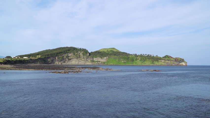 Side view of Songaksan in Jeju island, Korea. The mountain is a parasitic volcano and it is a attraction famous for its beautiful scenery and Olle trail.