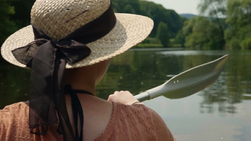 Young girl canoeing and smiling in a beautiful lake on sunny water in 4k