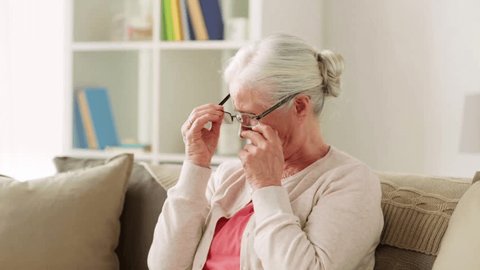 old age, health and people concept - senior woman with glasses having vision problem at home
