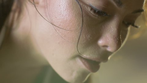 Close-up Shot of a Beautiful Athletic Woman Wipes Sweat from Her Forehead with a Hand, Looks into Camera. She's Tired after Intensive Cross Fitness Exercise. Shot on RED EPIC-W 8K Helium Cinema Camera
