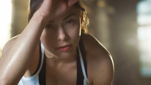 Beautiful Athletic Woman Wipes Sweat from Her Forehead with a Hand, Looks into Camera. She's Tired after Intensive Cross Fitness Exercise. Shot on RED EPIC-W 8K Helium Cinema Camera.
