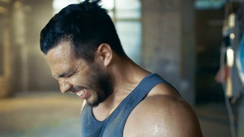 Exhausted Muscular Man Screams In Anger after Exhausting Gym Workout. He Wipes Sweat from His Face, He Wears Singlet. Shot on RED EPIC-W 8K Helium Cinema Camera.