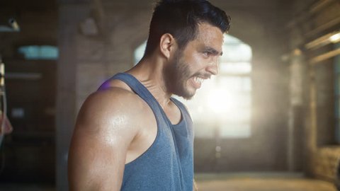Exhausted Muscular Man Screams In Anger after Exhausting Gym Workout. He Wipes Sweat from His Face, He Wears Singlet. Shot on RED EPIC-W 8K Helium Cinema Camera.