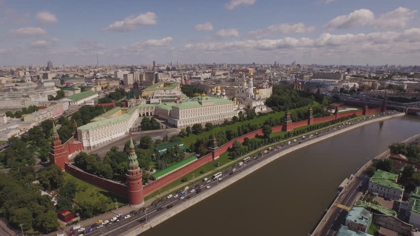 Kremlin complex on quay with traffic at spring day in Moscow. Golden dome churches, river. 4k