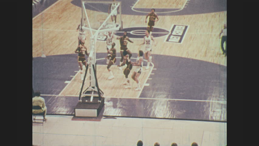1970s: Teams play basketball. Feet in sneakers run on basketball court. Woman figure skates in ice rink. Woman falls on ice. Man slips in water while playing soccer. Man crashes while water skiing