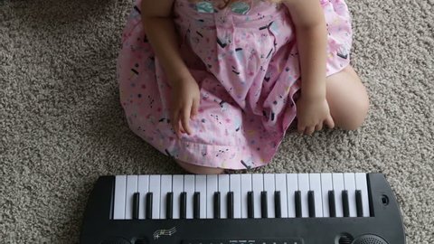 Child little girl playing on a toy piano. Full HD video