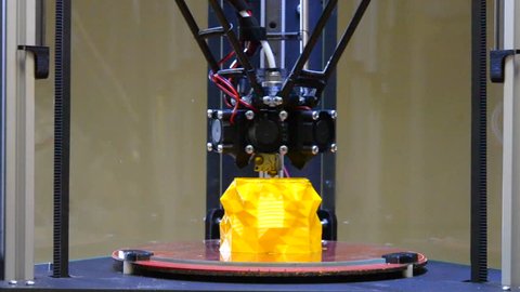 3d printing printer bright yellow model close-up. Automatic 3D printer performs plastic modeling in laboratory. Modern additive technologies, 4.0 industrial revolution. Timelapse