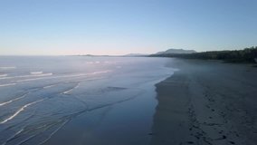 Aerial view of the beautiful coast on Pacific Ocean during a summer sunrise. Video taken near Tofino and Ucluelet in Vancouver Island, British Columbia, Canada.