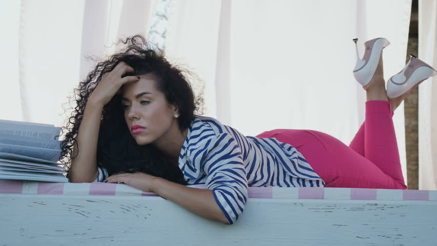 Upset young girl relaxes at summer terrace of country house