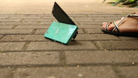 The smartphone falls on the asphalt on the street and splits into parts. 4k