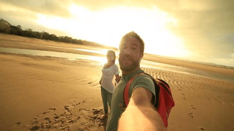 Young couple on beach take selfie portrait with Australian flag
Young couple on the beach at sunset take a selfie portrait while holding an Australian flag in the air.