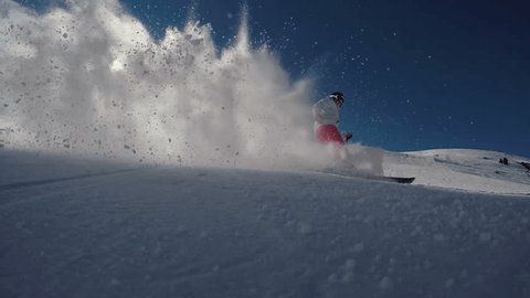 Super slow motion shot of a young woman skiing in the Swiss alps.
Skier carving and spraying snow at camera