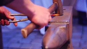 Making a Guard For the Sword. a Man is Engaged in Making a Guard For an Ancient Sword. it Works With a Strong Refractory Metal. the Man Uses Simple Tools. Video in a Super Slow-Motion Mode.