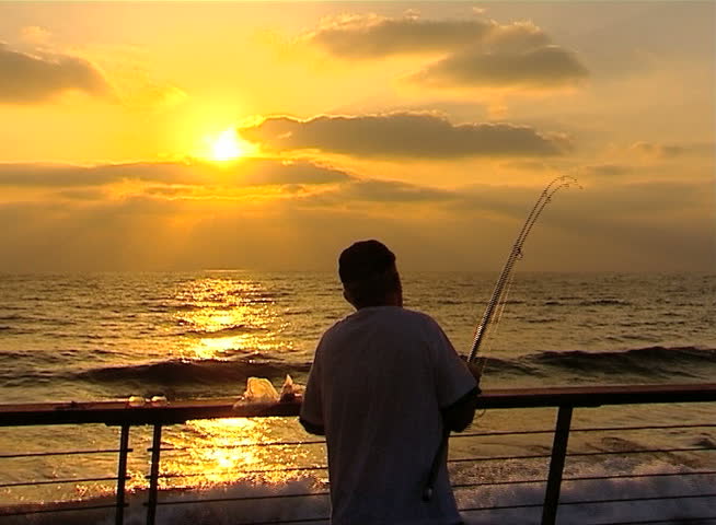 Fisherman fishing at sunset