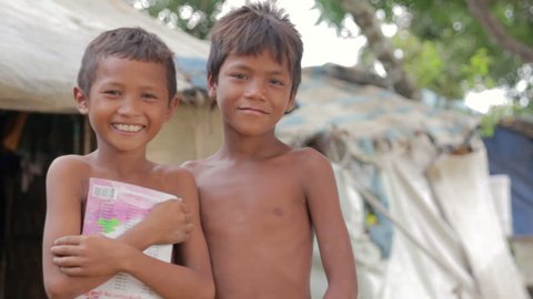 Cambodian boys in slum, shacks at background