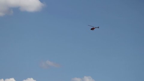 Helicopter in flight.Beautiful clouds on the background.Single-engined helicopter with semi-rigid two-bladed main rotor, two-bladed tail.
