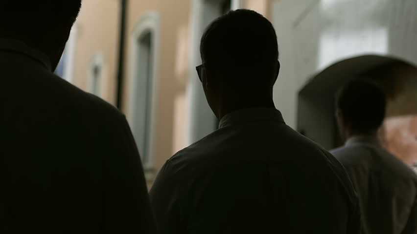Men walk along a dark alley slow motion