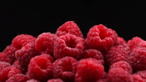 Raspberry rotation over black Background. Ripe fresh and juicy raspberries rotated close-up, isolated on black. Organic berry, healthy food. Diet, dieting 4K UHD video 3840X2160