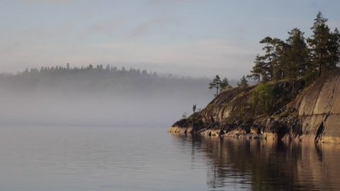 Strong fog on Ladoga lake. Island in Russia. Skerries.
