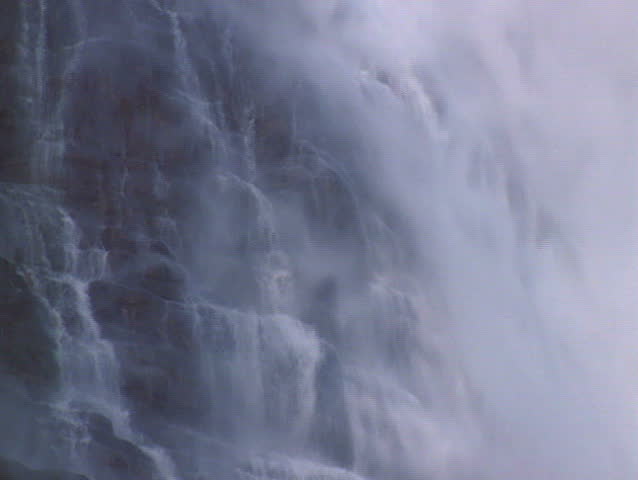 Misty waterfall cascading down rockwall