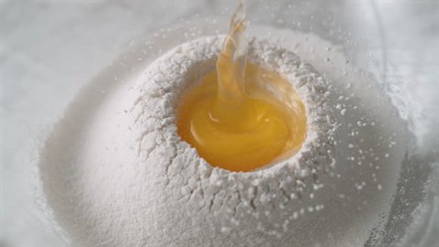 Egg falls on a pile of flour. Shot with high speed camera, phantom flex 4K. Slow Motion.
