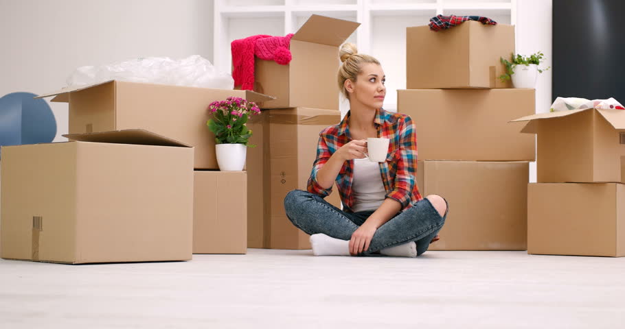 Young woman decorating her new house relaxing on the floor with a mug of coffee
