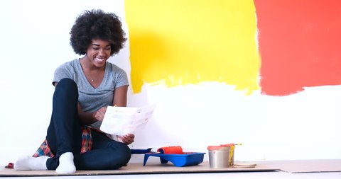 black woman relaxing during renovations to her new home sitting on the floor