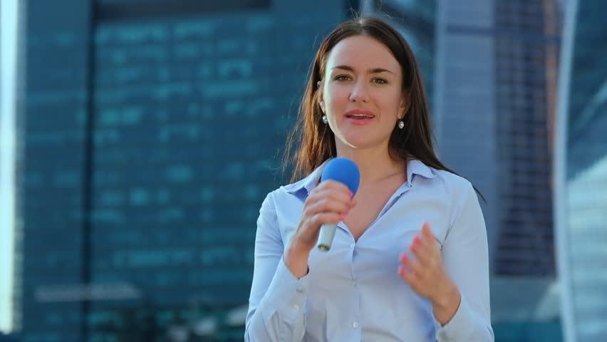 Young girl TV reporter is broadcasting on modern city background