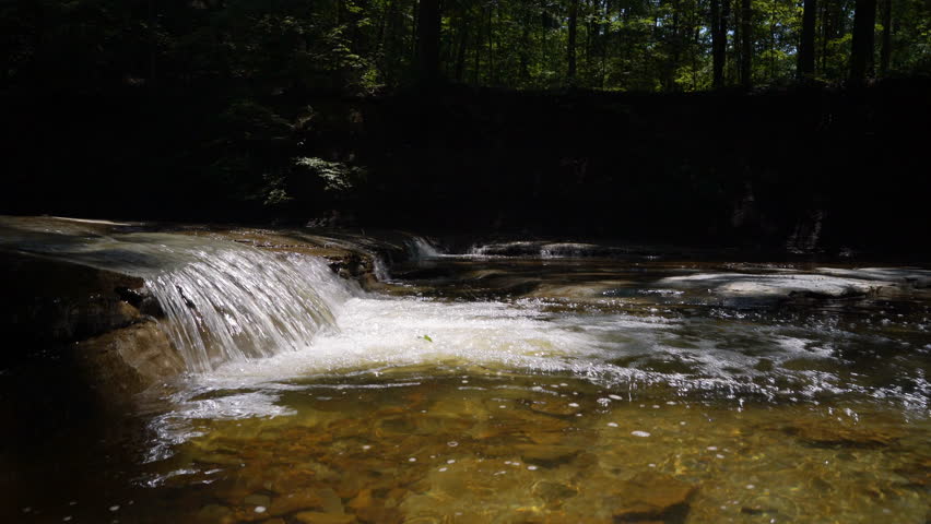 Crane shot over small waterfall in ohio stream