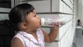 Asian little baby eating milk from bottle with enjoy, 1Year 10 months.