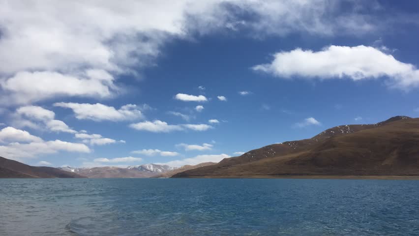 beautiful lake arounded by high mountain in blue cloud sky