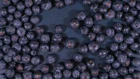 Blueberries on dark blue wood table overhead, reversing to copy space.
