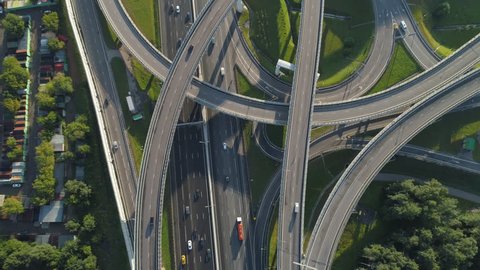 Multi-level road junction and cars traffic. Camera is tilting up. Aerial vertical shot.