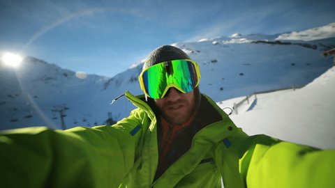 Man taking self portrait from ski slope.
Young man skiing in Switzerland takes a selfie 