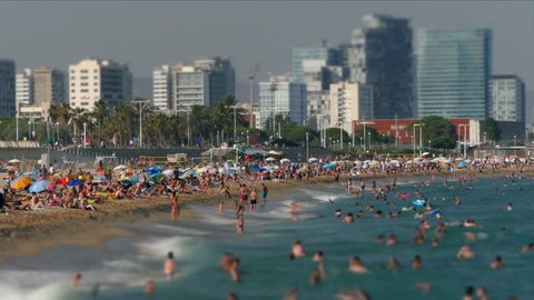 BARCELONA, SPAIN - AUGUST 03, 2017: Beaches and architecture of Barcelona.
Activity on the beaches of the city of Barcelona with skyscraper background, a summer day.Time lapse.Long exposure.Tilt-shift
