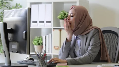 professional young female muslim worker tired about company cooperation case feeling sleepy and sitting in office thinking solution.