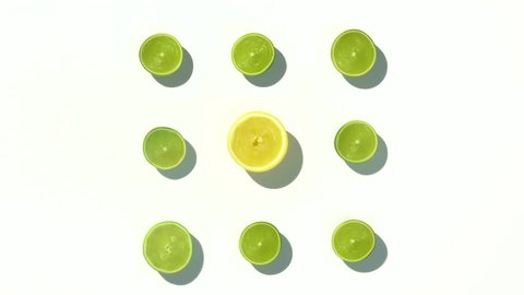 Lemons and limes chopped in half and spinning on a white surface